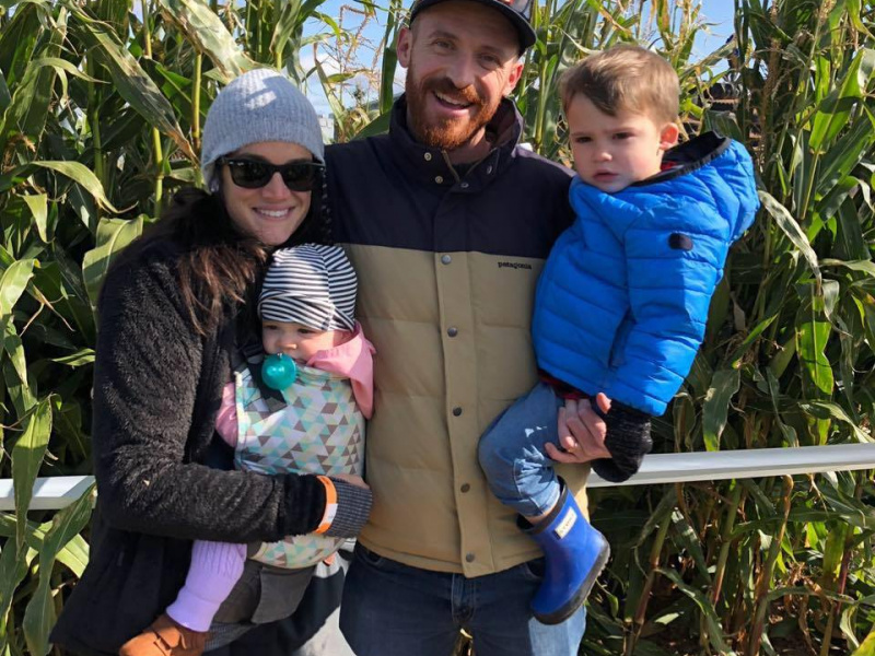 Harnish Family bundled up from cold smiling in front of corn field during the fall season.