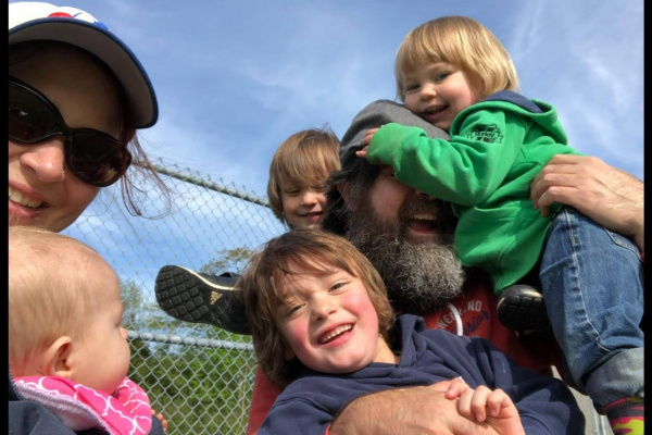 Herlihy family smiling, laughing and playing at a local field.